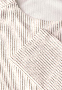 Nahaufnahme von beige- und weißgestreiftem Rippstrickstoff mit Rundhalsausschnitt und umgeschlagenem Ärmelsaum.