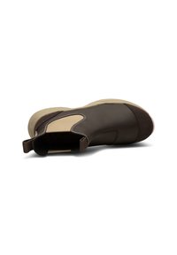 Botín de cuero marrón con acentos beige. Cuenta con paneles laterales elásticos, punta redonda y suela de goma texturizada para un mejor agarre.