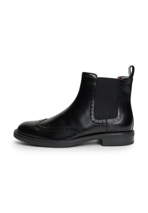 Schwarzer Chelsea-Lederknöchelboot mit Brogue-Details, elastischen Seiteneinsätzen, niedrigem Absatz und Zuglasche hinten.