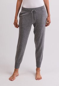 Graue Strick-Sweatpants mit einem Kordelzug am Bund, schmal zulaufenden Bündchen und Seitentaschen. Hergestellt aus weichem Stoff mit einer glatten Textur.