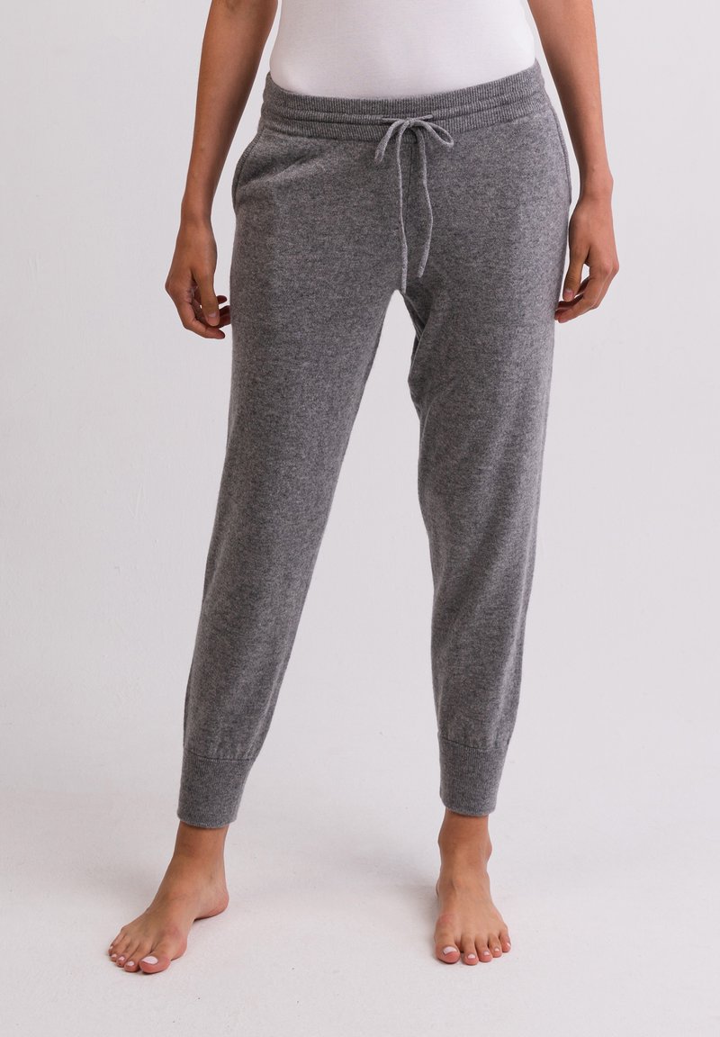 Graue Strick-Sweatpants mit einem Kordelzug am Bund, schmal zulaufenden Bündchen und Seitentaschen. Hergestellt aus weichem Stoff mit einer glatten Textur.