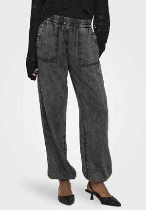 Gray denim wide-leg pants with contrasting stitching, elastic waistband, and front pockets. Paired with black pointed-toe heels.