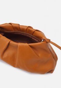 Braunes Leder-Armbandtäschchen mit gerafftem Design und sichtbarem Reißverschluss auf weißem Hintergrund.