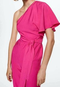 Combinaison fuchsia avec une épaule dénudée, large manches évasées, accent à la taille nouée et texture lisse.