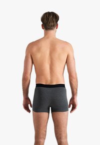 Caleçons boxers en coton gris avec une taille noire, présentant un design ajusté et une texture lisse, vus de dos.