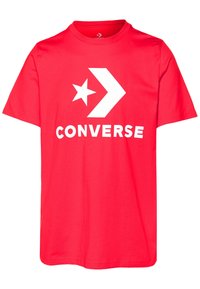 Punainen puuvillainen T-paita, jossa on valkoinen tähti ja nuoli -suunnittelu sekä "CONVERSE"-teksti, joka on painettu näkyvästi eteen. Lyhyet hihat, pyöreä kaula-aukko.