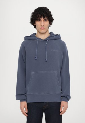 Navy blue hoodie made of fleece with a kangaroo pocket, drawstring hood, and ribbed cuffs. Features subtle logo detail on chest.