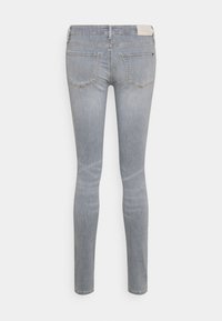 Kapeat farkut vaaleanharmaasta denimmateriaalista. Mikä sisältää kaksi takataskua, huomaamatonta tikkausta ja pienen logotagin vyötärönauhassa. Sileä pinta.