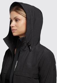 Black hooded jacket with a smooth texture, featuring a zip closure, adjustable drawstrings, and logo detail on the chest.