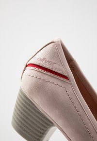 Světlé růžové kožené lodičky na vysokém podpatku s texturovaným šedým blokovým podpatkem, které mají červený akcentový pruh a jemné detaily šití.