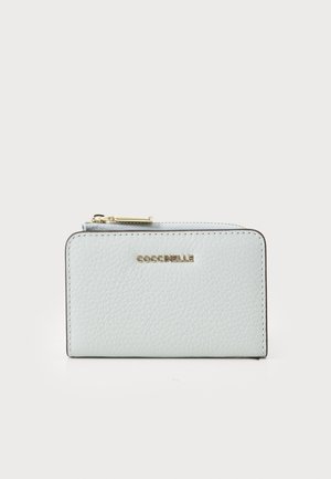 Portafoglio in pelle azzurro chiaro con finitura texturizzata, hardware in tono dorato e logo sulla parte anteriore. Presenta una chiusura con zip.