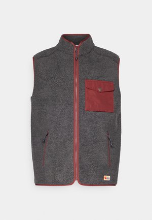 Sötét szürke fleece mellény piros díszítéssel, elöl egy zsebbel, két oldalsó zsebbel és magas gallérral. Puha, texturált felület.