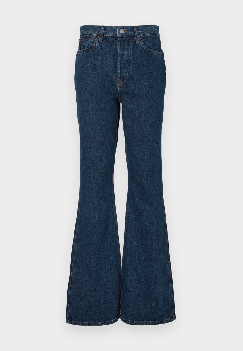 Dark blue flared jeans made of denim. Features high waist, five pockets, and contrast stitching. Smooth texture and clean finish.