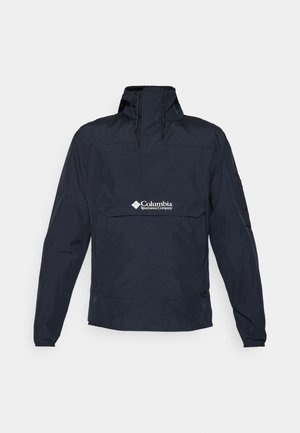 Tums zila anoraka jakas, kas izgatavota no viegla materiāla, ar augstu apkakli, priekšējo kabatu un logotipu krūšu rajonā. Iekļautas garas piedurknes.