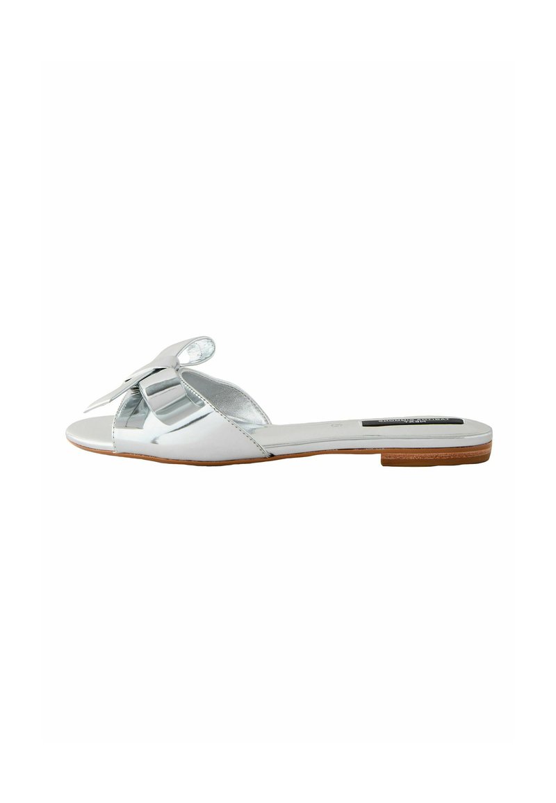 Zilveren platte slip-on sandalen met een grote decoratieve strik, open teen ontwerp en een gestructureerde bruine zool. Glad synthetisch bovenmateriaal.