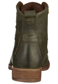 Olivově zelená kožená kotníková bota s kulatou špičkou, kontrastním prošíváním, vrstvou dřevěného podpatku a měkkou hnědou podšívkou.