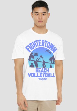 Weißes Baumwoll-T-Shirt mit einem blauen Grafikdesign, das den Text "FIGHTERTOWN BEACH VOLLEYBALL", Silhouetten von Spielern, Palmen und die Sonne zeigt.