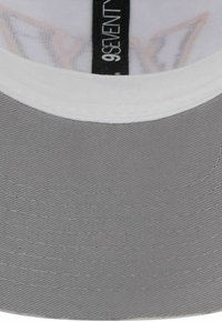 Gray hat with a white band, made of fabric with a textured finish. Inside displays a label and a colorful pattern.