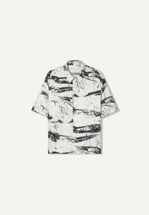 Short-sleeve shirt in black and white with abstract paint-like pattern, collared design, and a loose, relaxed fit. Lightweight fabric.