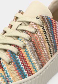 Αθλητικό παπούτσι με υφαντό σχέδιο σε πολύχρωμες αποχρώσεις· κορδόνια και γλώσσα σε κρεμ απόχρωση· υφή στη σόλα από καουτσούκ· μεταλλικές φιγούρες για τα κορδόνια.