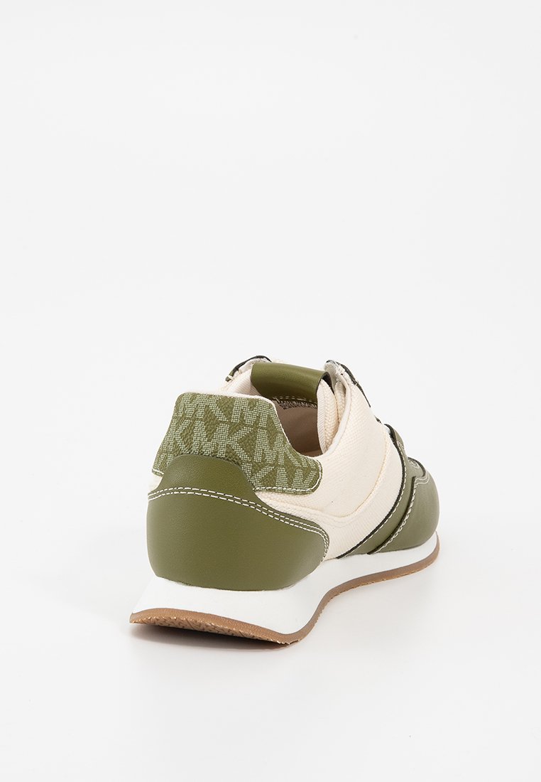 Sneaker con suola in gomma verde, parte superiore in tela crema e accento sul tallone verde texturizzato. Presenta un pannello posteriore stampato e una cinghia regolabile.