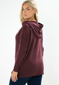 Burgundy stickad huvtröja med en avslappnad passform, framfickor i kängurustil och ribbade cuffs och nederkant. Mjuk textur och avslappnad design.