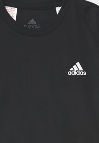 Juodas sportinis marškinėlis, pagamintas iš lygaus audinio, su apvalia iškirpte ir trumpomis rankovėmis, su baltu "Adidas" logotipu kairiajame krūtinės taške.