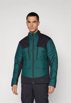 Veste isolante verte et noire avec un col haut, texture matelassée, fermeture éclair à l'avant et deux poches zippées sur la poitrine.