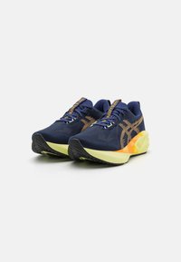 Zapatillas de correr color azul marino con una parte superior texturizada, detalles en naranja y suela amarilla. Presentan un diseño ligero y una suela exterior de goma para mayor tracción.