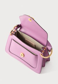 Ανοιχτή δερμάτινη τσάντα χιαστί σε λιλά χρώμα, που αποκαλύπτει ευρύχωρο εσωτερικό και μπροστινή τσέπη με χρυσό κυκλικό κούμπωμα και λαβές από χρυσό μεταλλικό δαχτυλίδι.