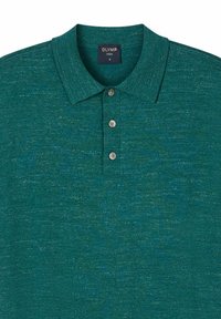 Grünes, strukturiertes Kurzarm-Poloshirt mit drei Knöpfen und einem marineblauen Label mit der Aufschrift „OLYMP CASUAL M“ am Kragen innen.