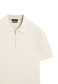 Polo manches courtes couleur crème avec col et demi-zip devant, en 100 % coton, étiqueté Massimo Dutti.