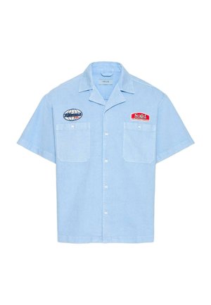 Jasnoniebieska koszula z krótkim rękawem na guziki, z dwoma kieszeniami na piersi oraz naszywkami z napisami "Solid" i "bionic".