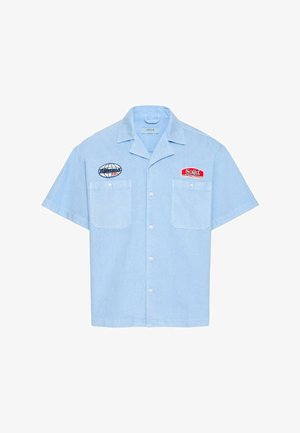 Lichtblauw kortärmlig hemd met knopen, twee borstzakken en geborduurde patches met de tekst "Solid" en "bionic."