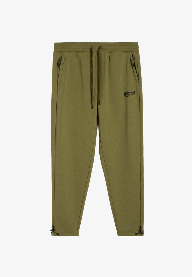 Jasnozielone dresy wykonane z miękkiego materiału, z elastycznym paskiem ze sznurkiem, kieszeniami zapinanymi na zamek oraz regulowanymi mankietami z trokami.