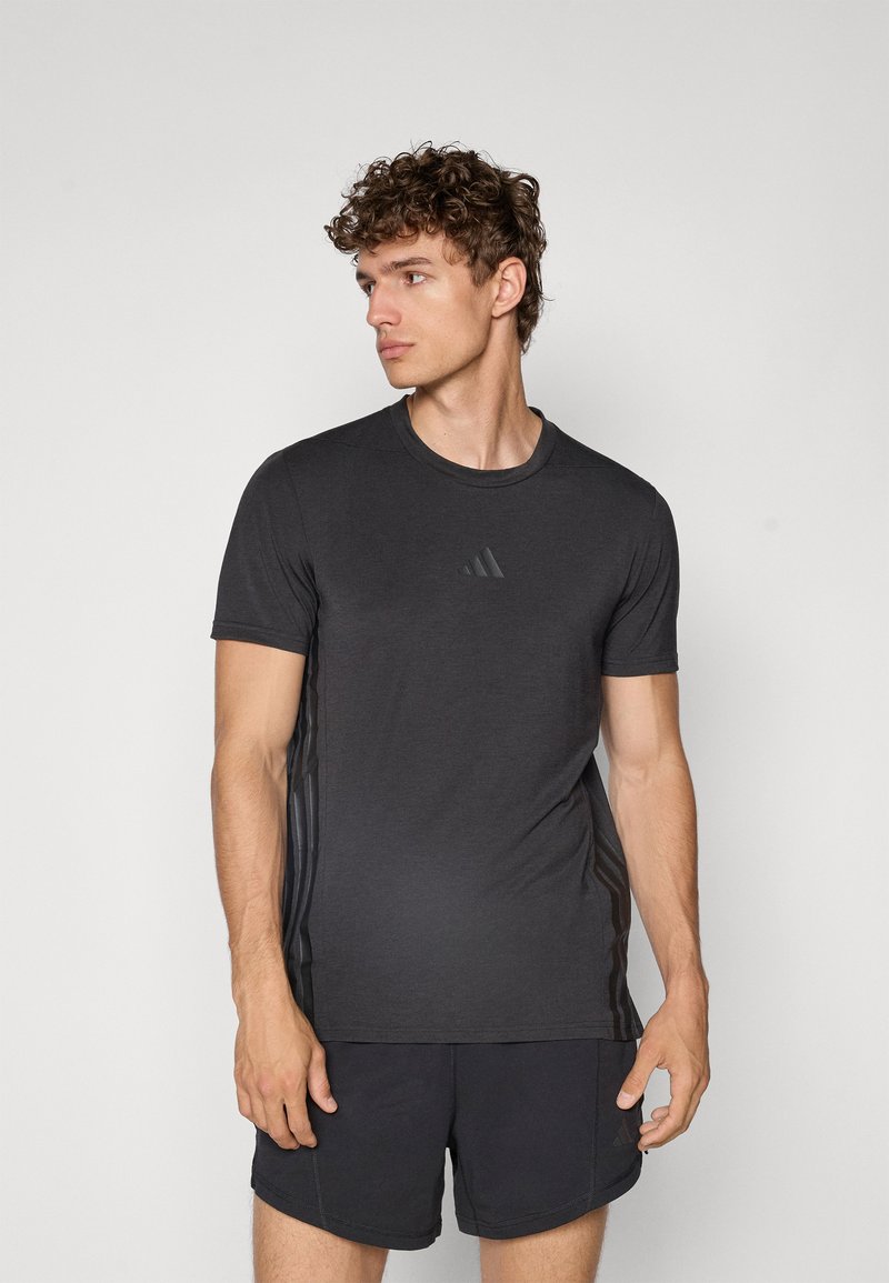 Schwarzes Sport-T-Shirt mit kurzen Ärmeln, Rundhalsausschnitt und dezentem Dreistreifen-Design an beiden Seiten. Glatter Stoff, normale Passform.