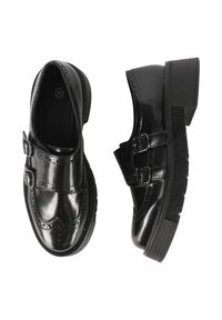 Scarpe in vernice nera con due fibbie regolabili, dettagli brogue e suola in gomma, con una finitura testurizzata.