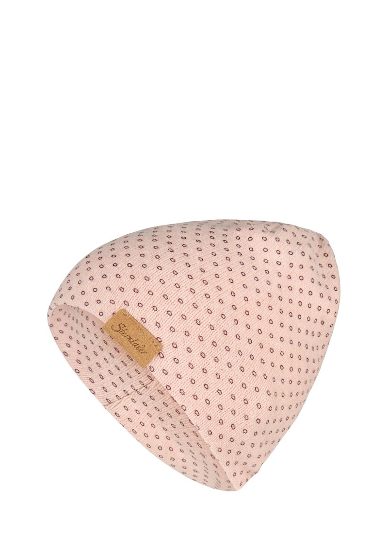Light pink knit beanie with small dark dots pattern and a tan rectangular leather label stitched on the side.