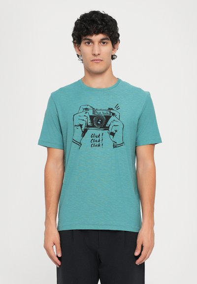 T-shirt in cotone color turchese con maniche corte e una stampa grafica di mani che tengono una fotocamera con la scritta "Click! Click! Click!" sotto.