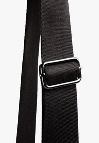 Correa de lona negra con una superficie texturizada, que cuenta con una hebilla de hardware plateado brillante para su ajuste. Diseño simple y funcional.