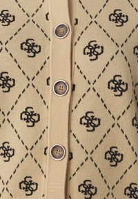 Cárdigan de punto beige con un patrón de diamantes negros y motivos florales, con botones en tono plateado y un acabado texturizado.