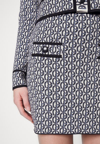 Rochie tricotată cu un model repetitiv în navy și crem, cu margini contrastante negre și un buton decorativ pe buzunar.