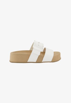 Mule blanche avec une large bride ornée d'une boucle, un semelle intérieure en suède beige et une semelle à plateforme épaisse.