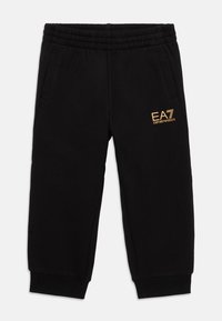 Crne trenirke s elastičnom pasicom, bočnim džepovima i zlatnim EA7 logotipom. Izrađene od mekog materijala s ležernim krojem i sužavajućim nogavicama.