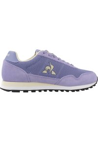 Chaussure de sport en mesh violet et suède avec une semelle intermédiaire blanche, un bout arrondi et une semelle extérieure en caoutchouc noir. Présente un accent de logo sur le côté.