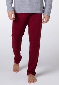 Pantaloni in cotone leggero color marrone scuro, dalla vestibilità comoda, con coulisse elastica in vita e design con gambe affusolate. Tessuto liscio, stile casual.