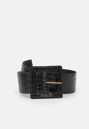 Zwarte nep-krokodillenleren riem met brede vierkante gesp en goudkleurig "GUESS" logo aan de voorzijde van de gesp.