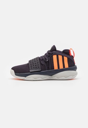 Black athletic shoe with orange accents, textured upper, adjustable strap, and a cushioned, white sole featuring a wave pattern.