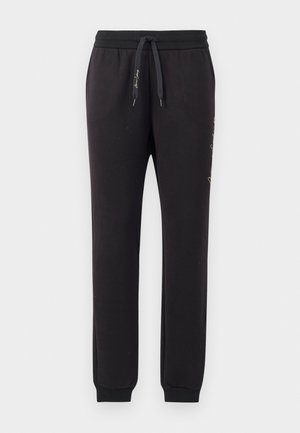 Sorte joggers lavet af blødt bomuld med elastisk talje og snoretræk. Har ribbede manchetter og broderet tekst på siden.