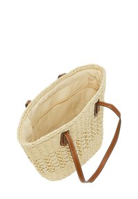 Geweven stro tote bag in lichtbeige kleur met brown leren handvatten. Het interieur heeft een ritszak en een soepele beige voering.